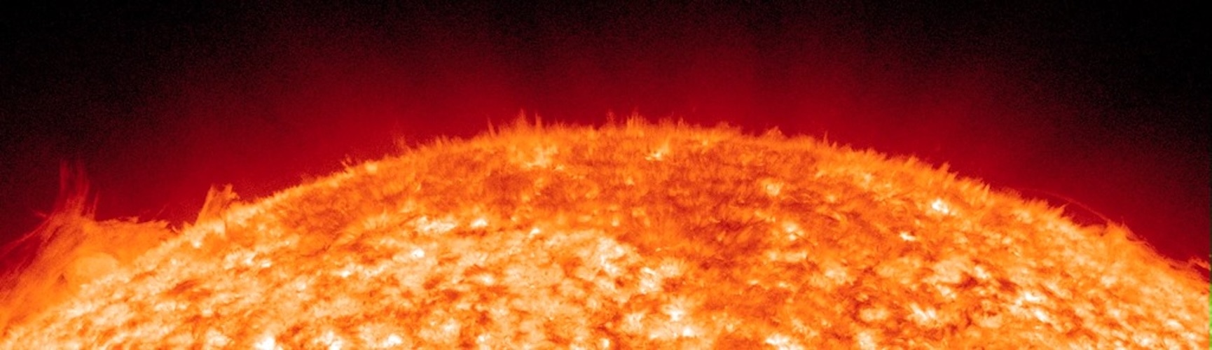 Край солнечного диска на снимке обсерватории SDO: над светящейся поверхностью поднимается бахрома из множества тонких тёмных и светлых струй плазмы, похожих на траву.